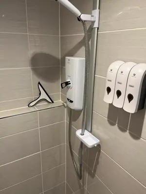 a shower in a bathroom with a hair dryer at Happy days Moreton , 2 miles from Hoylake Wirral in Moreton