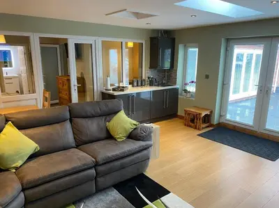 a living room with a couch and a kitchen at Happy days Moreton , 2 miles from Hoylake Wirral in Moreton