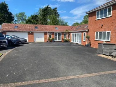 a brick house with a parking lot in front of it at Happy days Moreton , 2 miles from Hoylake Wirral in Moreton