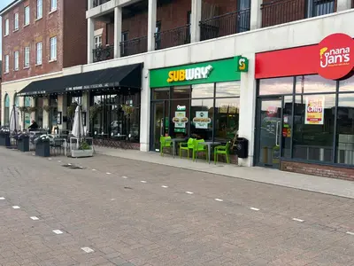 a store front with tables and chairs in a street at Buckshaw Snoozy in Heapey