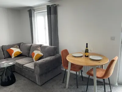 a living room with a couch and a table at Buckshaw Snoozy in Heapey