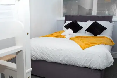 a bed with a teddy bear sitting on top of it at Bloomfield Apartments in Blackpool