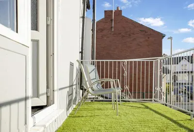 a chair sitting on a balcony with green grass at Bloomfield Apartments in Blackpool