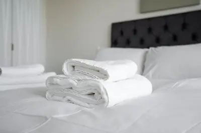 a pile of towels sitting on top of a bed at GuestReady - A lovely hideaway in Vauxhall in Liverpool
