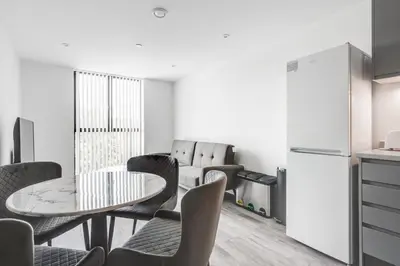 a kitchen with a table and chairs and a refrigerator at GuestReady - A lovely hideaway in Vauxhall in Liverpool
