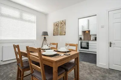 a kitchen and dining room with a wooden table and chairs at DACY LODGE, Anfield - Strictly NO Parties in Liverpool