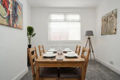 a dining room with a wooden table and chairs at DACY LODGE, Anfield - Strictly NO Parties in Liverpool