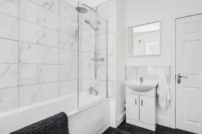 a white bathroom with a shower and a sink at DACY LODGE, Anfield - Strictly NO Parties in Liverpool
