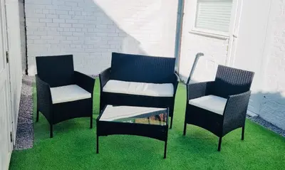 three chairs and a table sitting on the grass at DACY LODGE, Anfield - Strictly NO Parties in Liverpool