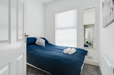 a bedroom with a blue bed with towels on it at DACY LODGE, Anfield - Strictly NO Parties in Liverpool
