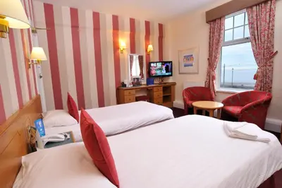 a hotel room with two beds and a television at Claremont Hotel - All Inclusive! in Blackpool