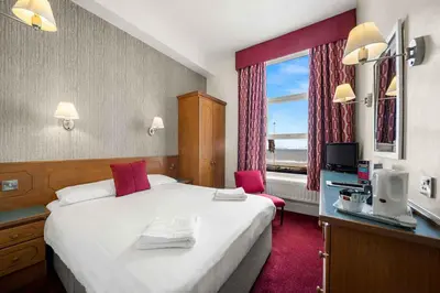 a hotel room with a large bed and a window at Claremont Hotel - All Inclusive! in Blackpool