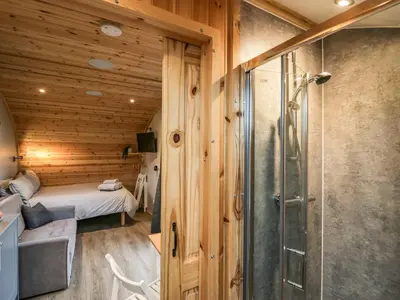a bathroom with a shower and a bed in a room at Orchard in Dalton in Furness