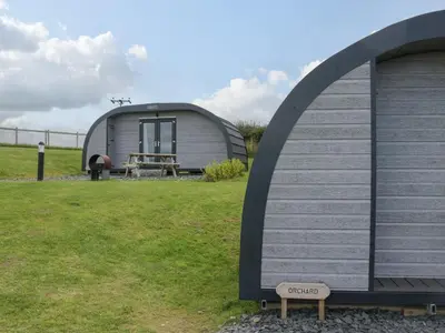 a dome shaped shed with a bench in a field at Orchard in Dalton in Furness
