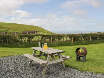a wooden picnic table with a grill and a picnic at Orchard in Dalton in Furness
