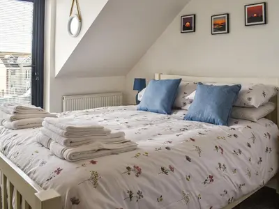 a bedroom with a white bed with blankets and pillows at Kingfishers Rest in Millom