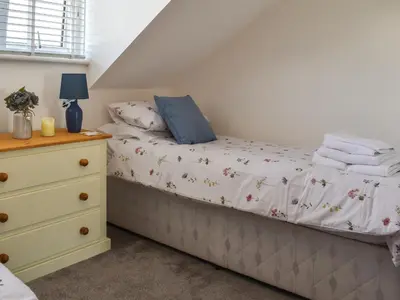 a bedroom with a bed and a dresser at Kingfishers Rest in Millom