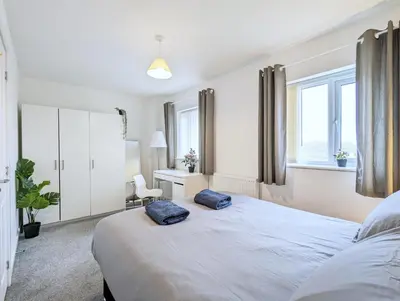 a bedroom with a large white bed with two pillows on it at Guest Rooms Near City Centre & Anfield Free Parki in Liverpool