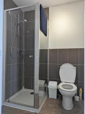 a bathroom with a toilet and a glass shower at Guest Rooms Near City Centre & Anfield Free Parki in Liverpool