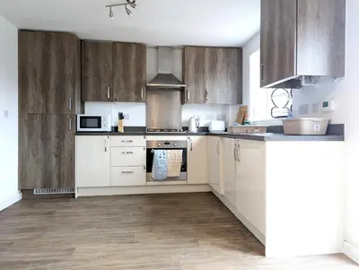 a kitchen with white appliances and wooden cabinets at Guest Rooms Near City Centre & Anfield Free Parki in Liverpool