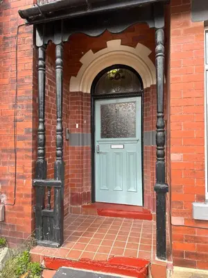 a blue door on a brick building with a brick sidewalk at The Big One Blackpool in Blackpool