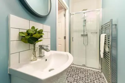 a bathroom with a white sink and a shower at Clock Tower Retreat - Sea View Apartments in Morecambe in Morecambe