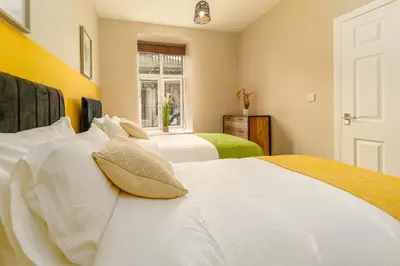 a bedroom with two beds and a window at Clock Tower Retreat - Sea View Apartments in Morecambe in Morecambe