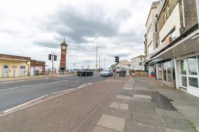 a city street with a clock tower in the distance at Clock Tower Retreat - Sea View Apartments in Morecambe in Morecambe