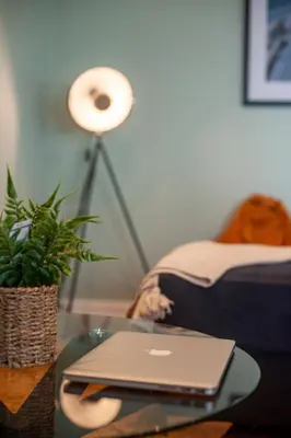a laptop sitting on a glass table in a living room at Clock Tower Retreat - Sea View Apartments in Morecambe in Morecambe