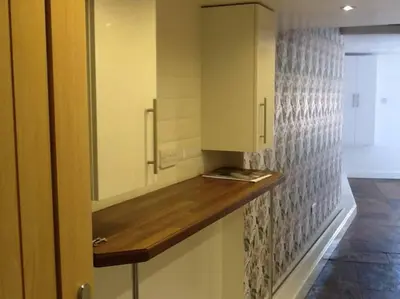 a kitchen with a counter top and a cabinet at Private garden apartment with secure parking in Southport