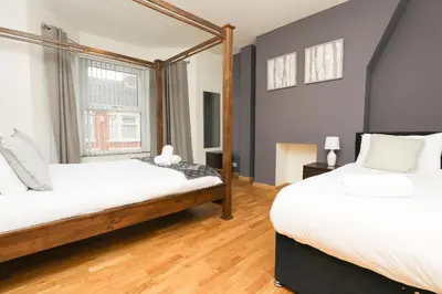 a bedroom with two beds and a window at Luxe Retreat - Steps from Stadium - Pool Table, Ping Pong, Football Table in Liverpool