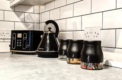a trio of coffee pots and a tea kettle on a counter at Luxe Retreat - Steps from Stadium - Pool Table, Ping Pong, Football Table in Liverpool