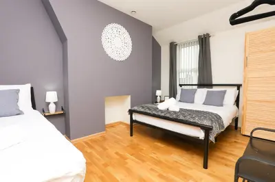 a bedroom with two beds and a bench at Luxe Retreat - Steps from Stadium - Pool Table, Ping Pong, Football Table in Liverpool