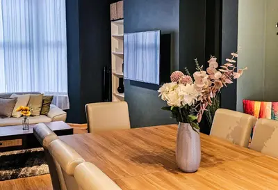a vase of flowers on a table in a living room at Luxe Retreat - Steps from Stadium - Pool Table, Ping Pong, Football Table in Liverpool