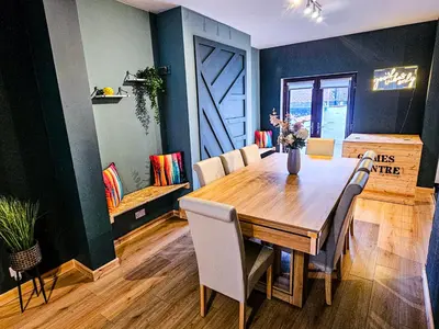 a dining room with a wooden table and chairs at Luxe Retreat - Steps from Stadium - Pool Table, Ping Pong, Football Table in Liverpool