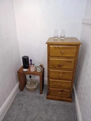 a dresser and a table with two wine glasses on it at Fylde Court in Morecambe