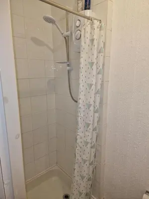 a shower with a shower curtain in a bathroom at Fylde Court in Morecambe