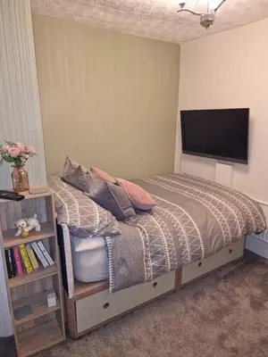 a bedroom with a bed and a flat screen tv at Fylde Court in Morecambe