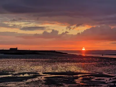 a sunset on the beach with the sun setting at Fylde Court in Morecambe