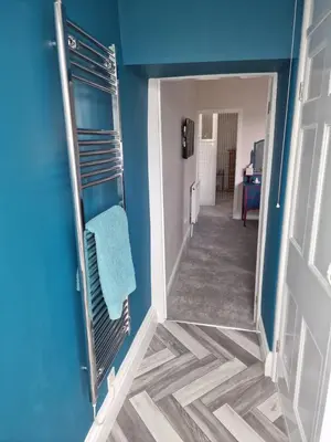 a hallway with a mirror and a blue wall at Fylde Court in Morecambe