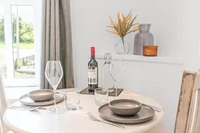 a table with a bottle of wine and glasses on it at The Black Dog Apartment in Dalton in Furness