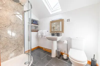a bathroom with a toilet and a sink and a shower at The Black Dog Apartment in Dalton in Furness