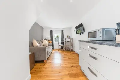 a kitchen and living room with a couch and a microwave at The Black Dog Apartment in Dalton in Furness