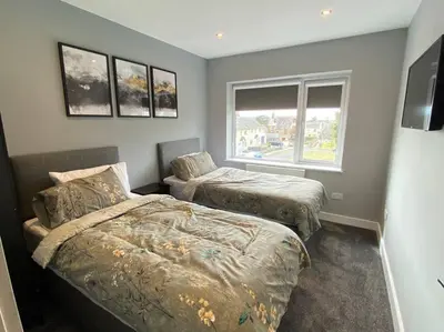 a bedroom with two beds and a window at A modern, dog-friendly 3 bedrm canal side property in Bolton le Sands