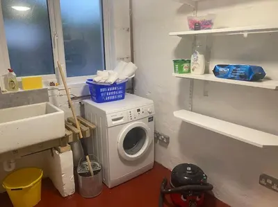 a laundry room with a washing machine and a sink at A modern, dog-friendly 3 bedrm canal side property in Bolton le Sands
