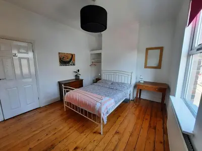 a bedroom with a bed and a wooden floor at Anfield Haven in Liverpool