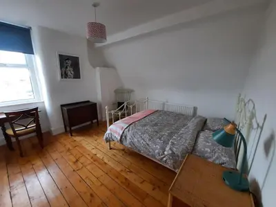 a bedroom with a bed and a wooden floor at Anfield Haven in Liverpool