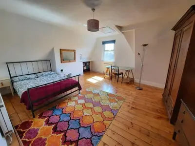 a bedroom with a bed and a rug on a wooden floor at Anfield Haven in Liverpool