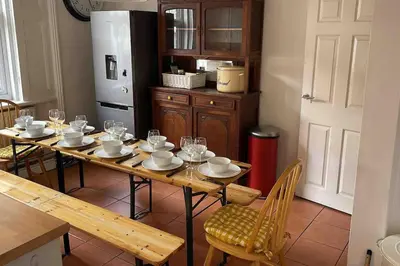 a kitchen with a table with chairs and a refrigerator at Anfield Haven in Liverpool