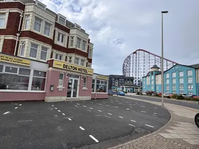 an empty parking lot with a roller coaster in the background at OYO Delton Hotel Blackpool Pleasure Beach in Blackpool